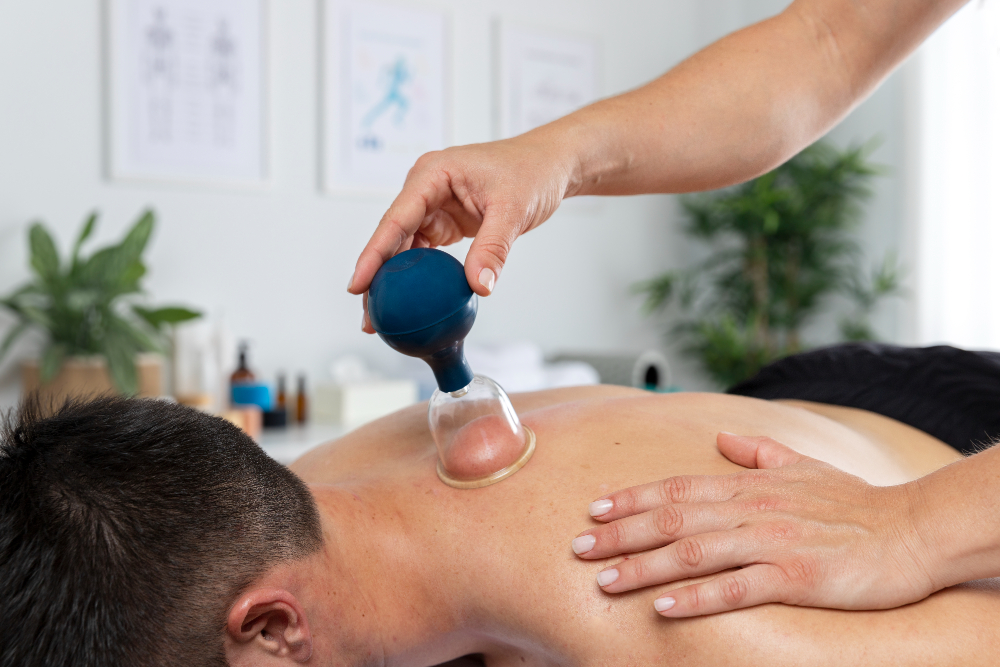 Fisioterapeuta realizando uma sessão de ventosaterapia em um paciente masculino.