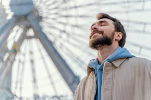 Homem respirando fundo e sorrindo após um momento de liberação emocional, inspirado pela massagem tântrica.